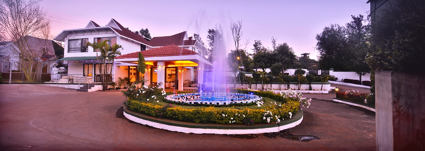 United 21 Resort entrance with a vibrant fountain, lush greenery, and warm lighting